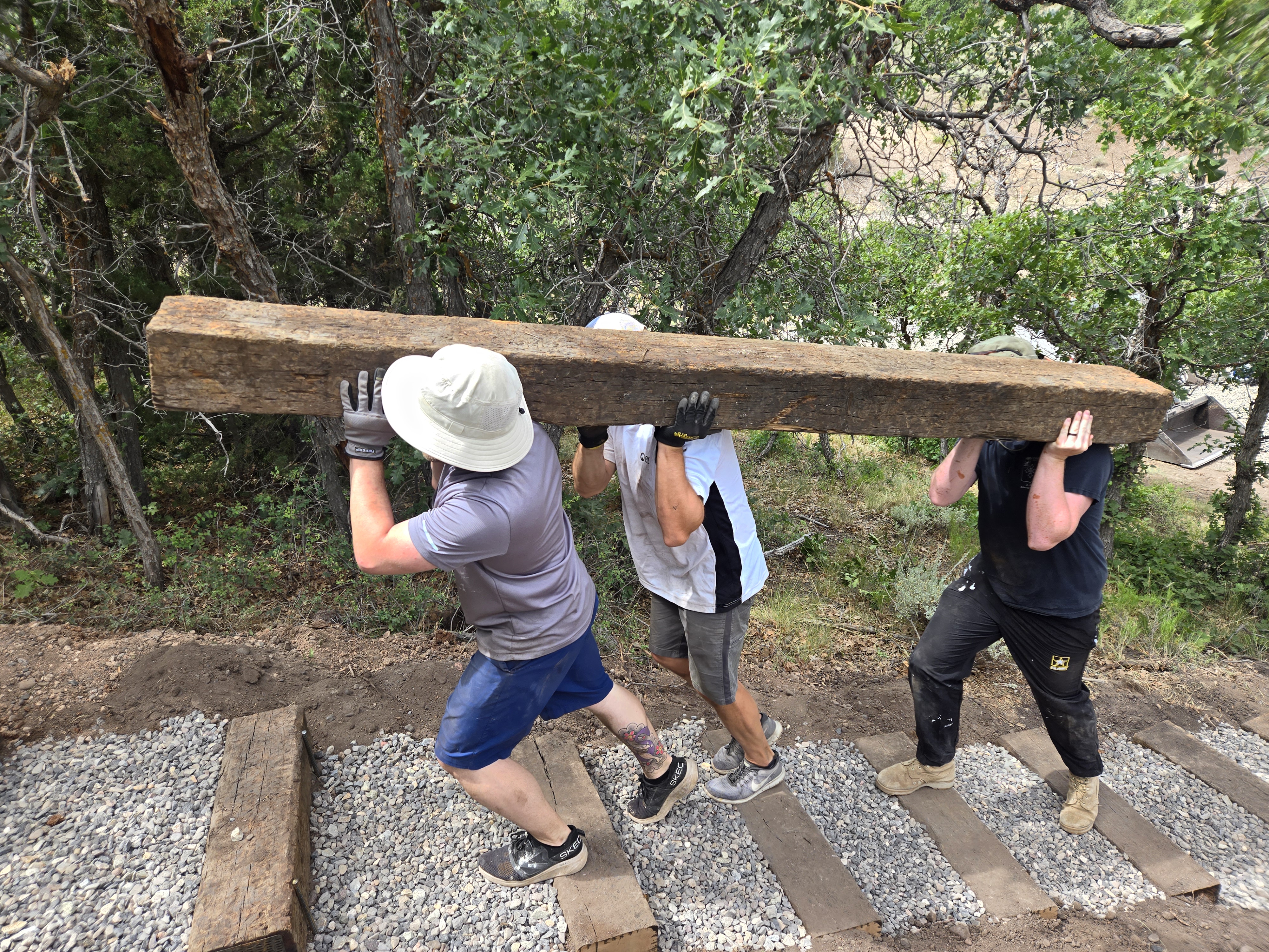Founders carrying railroad tie beams to build the stairs