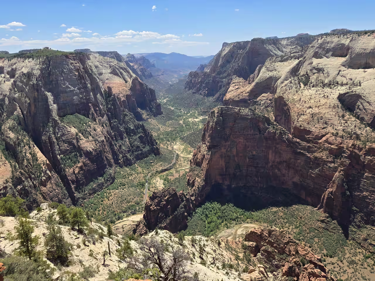 Aerial-style view from Observation Point down to the Zion Canyon floor with the scenic drive road visible