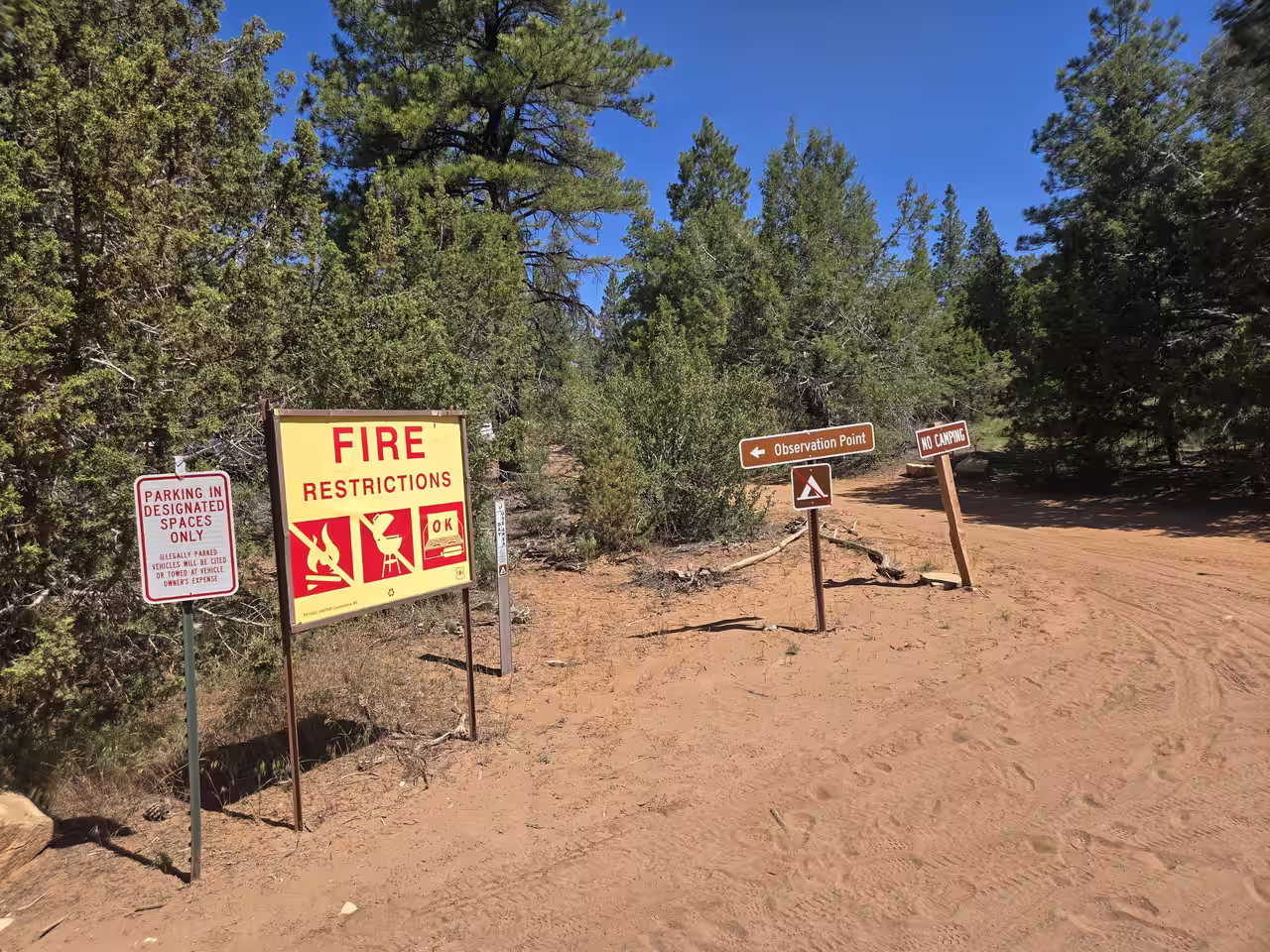 Trailhead signage showing fire restrictions, no camping, and parking rules at East Mesa Trailhead